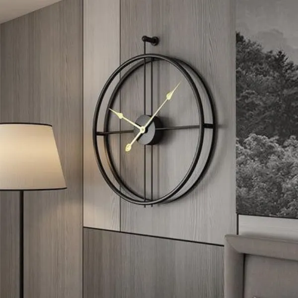 alt text: Một chiếc đồng hồ treo tường sắt mỹ thuật với thiết kế độc đáo, được đặt giữa các bức tranh, tạo nên sự hài hòa và sang trọng.